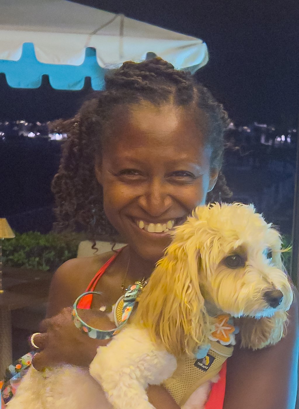Darline Lalanne laughing and holding her fluffy cream-colored dog